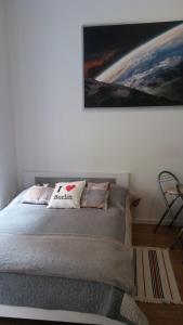 a bedroom with a bed with a painting on the wall at Ferienwohnung in Berlin