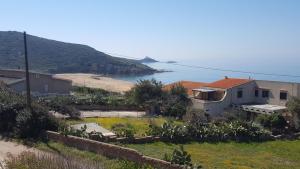 a house on a hill next to a beach at Appartamento Bouganville in Magomadas