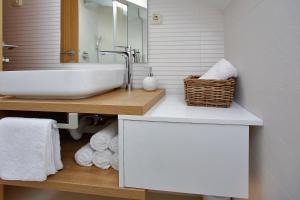 uma casa de banho branca com um lavatório e um espelho em Apartments Nina em Bibinje