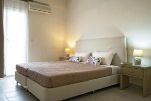 a bedroom with a large bed with two pillows at KORMORANOS BEACH in Acharavi