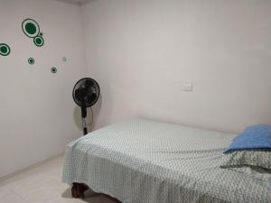 - une chambre avec un lit et un ventilateur dans l'établissement Apartamentos Maiver, à Ríohacha
