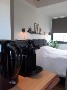 a hair dryer sitting on a table next to a bed at Room at the Beach Egmond in Egmond aan Zee