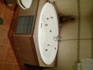 a bath tub in a bathroom with a toilet at Hostal Piñera in Vega de Espinareda