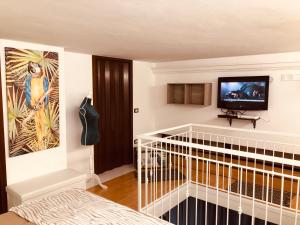 a bedroom with a crib and a tv on a wall at La Dimora del Viaggiatore Luxury Apartments in Mazara del Vallo