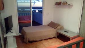 Habitación con cama, TV y mesa. en El Mirador de la Desembocadura, en Ayamonte