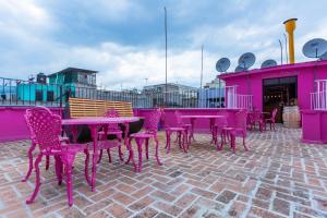 un gruppo di tavoli e sedie viola su un patio di Mala Vecindad Beer Hotel a Città del Messico