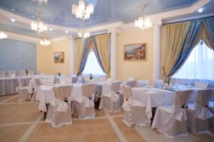 リペツクにあるBusiness Hotelのテーブルと椅子(白いテーブルクロス付)が備わる客室です。