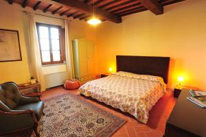 1 dormitorio con 1 cama, 1 silla y 1 ventana en Agriturismo Streda Wine & Country Holiday en Vinci