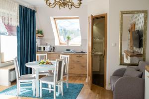 a small kitchen and dining room with a table and chairs at Apartamenty Ciche Wzgórze Zakopane in Zakopane