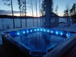 a jacuzzi tub with lights in the snow at Jacuzzi Rantakallio in Melkoniemi