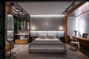 een slaapkamer met een bed en een bureau bij King's Blue, Urban Suites in Heraklion