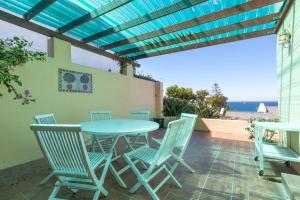 een tafel en stoelen op een patio met uitzicht op de oceaan bij Seascape Cottage in Kaapstad