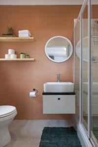 een badkamer met een wastafel en een spiegel bij Seascape Cottage in Kaapstad