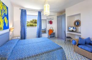 a bedroom with a blue bed and a window at Hotel La Scogliera in Ischia +37 photos