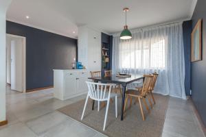 een keuken en eetkamer met een tafel en stoelen bij Seascape Cottage in Kaapstad +11 foto's