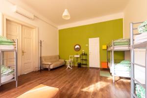a room with a green wall and bunk beds at Fluxus Hostel in Ljubljana