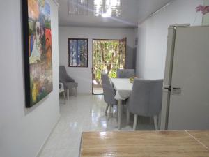 une salle à manger avec une table et des chaises blanches dans l'établissement Apartamentos Maiver, à Ríohacha