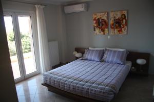 een slaapkamer met een bed en een glazen deur bij Thalatta Seaside Accommodation in Psilí Ámmos