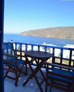 uma mesa e cadeiras numa varanda com vista para o oceano em Pension Christina em Aegiali