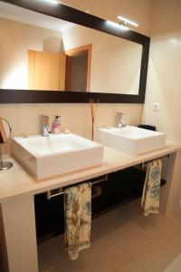 uma casa de banho com 2 lavatórios e um espelho grande em 20 da Vila - Apartment with Terrace em São Bartolomeu de Messines