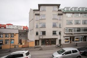dos autos estacionados frente a un edificio alto en AVA Apartments by Heimaleiga en Reikiavik