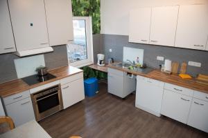 cocina con armarios blancos y ventana grande en Zimmer in Celle, en Celle