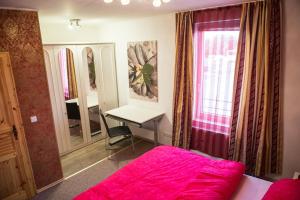 1 dormitorio con cama rosa y escritorio en Zimmer in Celle, en Celle
