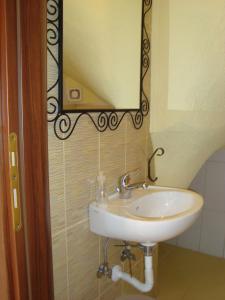 a bathroom with a sink and a mirror on the wall at Villaathena in Skála Foúrkas