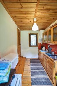 eine Küche mit Holzschränken und einer Holzdecke in der Unterkunft Leśna Polana in Górzno