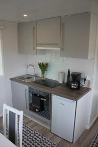 a kitchen with a sink and a stove at Stuga på Hammarbergs Gård in Kungsbacka