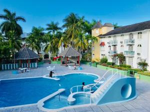 a swimming pool at a resort with a slide at Beach PentHouse A25 Sandcastles in Ocho Rios