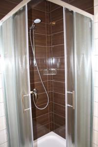 a shower with a glass door in a bathroom at Apartments Sandra in Rab