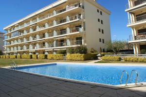 un hotel con piscina frente a un edificio en APARTAMENTO EN ROSES A 2 MINUTOS DE LA PLAYA CON VISTA AL MAR, en Girona