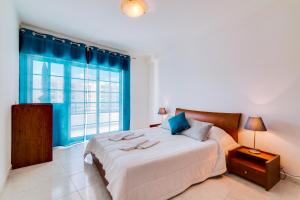 une chambre avec un grand lit et une fenêtre dans l'établissement Rei - Quarteira - 3 min to the beach, à Quarteira