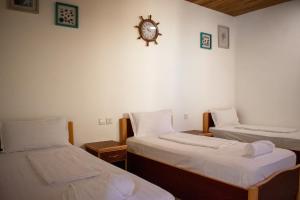 a room with two beds and a clock on the wall at Darna Divers Village in Aqaba