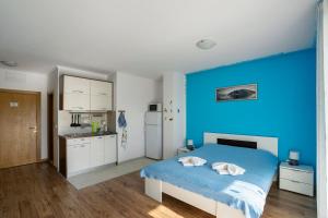 a blue bedroom with a bed and a blue wall at Apartments Viktoria in Tivat