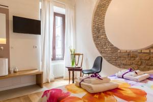 a bedroom with a bed with a chair and a mirror at Tolomeo Apartment in Rome