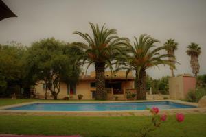 una casa con palmeras y piscina en Es garballons, en Manacor