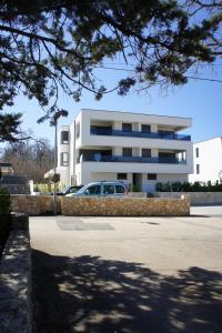 a car parked in front of a white building at Apartment White in Vantačići