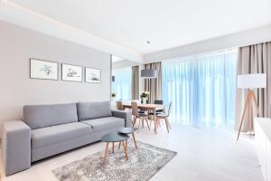 a living room with a couch and a table at Mielno Dune B Apartamenty in Mielno