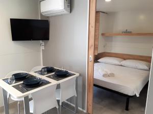 a small room with a table and a bed at OTIUM mobile homes in Biograd na Moru