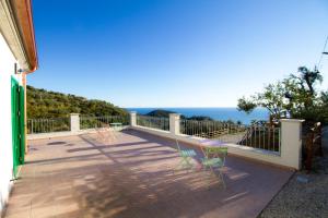 a balcony with chairs and the ocean in the background at Country House “ Il Mandorlo” in Acciaroli