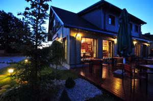 a house with a deck with chairs and an umbrella at Rowing Hotel in Trakai