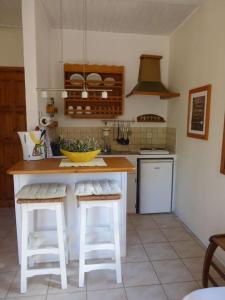 a kitchen with a counter and stools in a kitchen at Aperi View in Karpathos