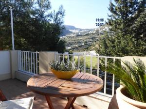 a wooden table with a plant on a balcony at Aperi View in Karpathos