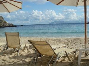 two chairs and an umbrella on a beach at Aperi View in Karpathos