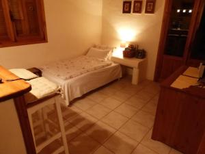 a small bedroom with a bed and a table at Aperi View in Karpathos