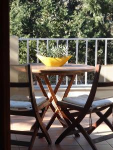 a wooden table with two chairs and a yellow bowl at Aperi View in Karpathos