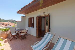 a patio with a table and chairs on a balcony at Aperi View in Karpathos
