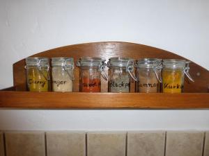 a wooden shelf with jars of food on it at Aperi View in Karpathos